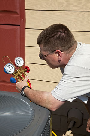 air conditioning technician checking refrigerant pressure
